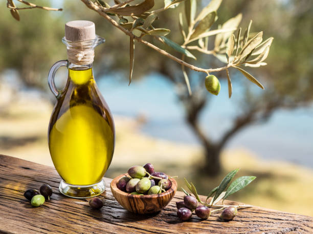 A bottle of olive oil with fresh olives. Image source: ValentynVolkov | Getty Images/iStockphoto